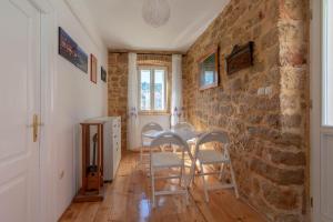 a dining room with a stone wall and a table and chairs at KUĆA ZA ODMOR “JADRANKA” in Zlarin