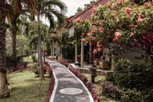 una pasarela frente a una casa con flores en The Hamsa en Lovina