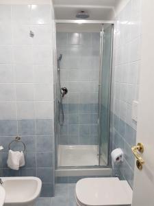 a bathroom with a shower with a toilet and a sink at Chiara Rooms in Rome