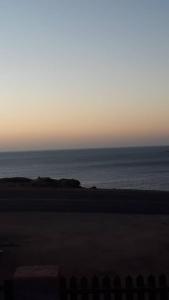uma vista para o oceano a partir da praia ao pôr-do-sol em Seabreeze Accommodation em Lüderitz