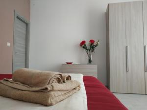 a bedroom with a bed and a vase of flowers at La Casa di Katia in Canicattì