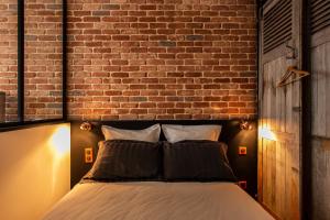 ルーアンにあるSuite Vintage Rouenのレンガの壁のドミトリールームのベッド1台分です。