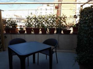 a table and chairs on a balcony with potted plants at Chiara Rooms in Rome