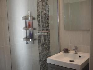 a bathroom with a sink and a shower with a mirror at le Camelia in Cassis