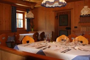 una sala da pranzo con tavolo, sedie e bicchieri da vino di Berggasthof Trattes a Valdaora