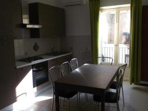 cocina con mesa, sillas y ventana en Via Giuseppe Garibaldi 115 en Lipari