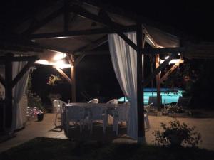 a table and chairs under a pavilion at night at Le Clos Lamy in Mont-près-Chambord