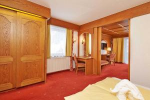 a hotel room with a bed and a desk and a bedroom at Hotel Alt Vent Tyrol in Vent