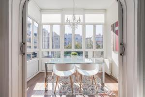 a dining room with a glass table and white chairs at Art House Fira Apartments in Barcelona