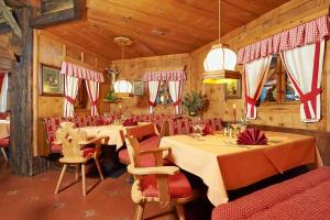 Hotel Alt Vent Tyrol في فنت: غرفة طعام مع طاولتين وكراسي حمراء