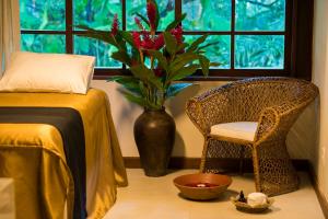 a room with a bed and a vase with a plant in a window at Tivoli Ecoresort Praia do Forte in Praia do Forte