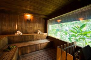 a sauna with a large window in a forest at Tivoli Ecoresort Praia do Forte in Praia do Forte