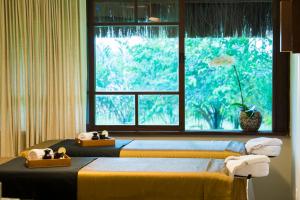 two beds in a room with a window at Tivoli Ecoresort Praia do Forte in Praia do Forte