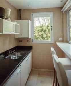 a small kitchen with a sink and a window at Suite House Carilo in Carilo