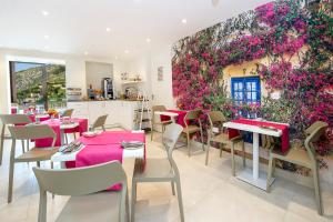 a restaurant with tables and chairs and a wall of flowers at Viewpoint Boutique Living in Xlendi