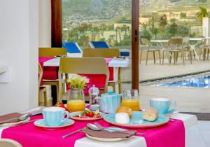 a table with plates of food on a pink table cloth at Viewpoint Boutique Living in Xlendi