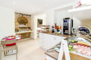 a kitchen with white cabinets and a counter with food at Viewpoint Boutique Living in Xlendi