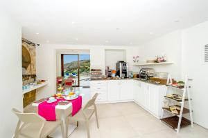 a kitchen with a table with a pink table cloth at Viewpoint Boutique Living in Xlendi