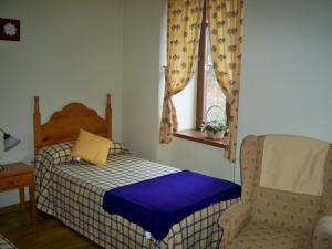 1 dormitorio con 1 cama, 1 silla y 1 ventana en Casa Es Neres en Les
