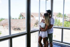 a woman and a man are standing in front of a window at Villas el Encanto Holbox in Holbox Island
