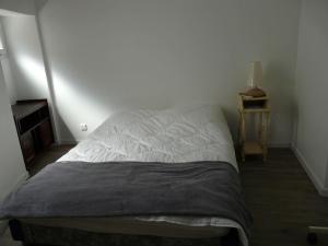 ein unmaskiertes Bett in einem Schlafzimmer mit einem Nachttisch in der Unterkunft T4 de 85m2 avec garage en plein coeur de Sète in Sète