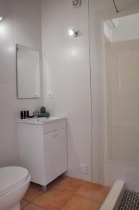 een badkamer met een toilet en een glazen douche bij Casa Silwa - Chic 2BR Townhouse, Ocean Views, 5min to Beach & Pool in Ferragudo