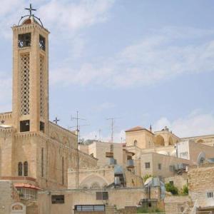 een gebouw met een klokkentoren in een stad bij Joseph apartment in Bethlehem