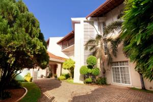 a white house with a driveway and trees at Villa 53 in Battaramulla