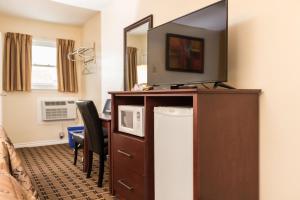 a hotel room with a television on top of a dresser at Park Place Motel & Suites in Tweed