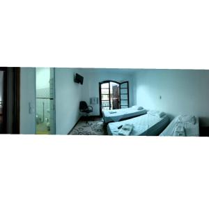 a room with two beds and a mirror at Anexo São João in Piracicaba +4 photos