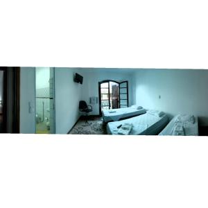 a room with two beds and a mirror at Anexo São João in Piracicaba