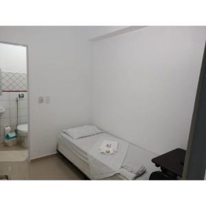 Habitación blanca con cama y aseo en Anexo São João, en Piracicaba