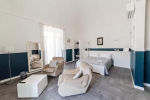 a bedroom with a bed and two chairs and a table at Novecento Dimore di Poesia in Trani