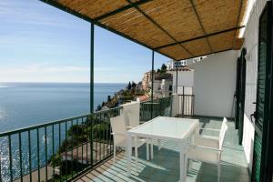 balcone con tavolo e sedie bianchi e vista sull'oceano di Amalfi Blue FLowers B ad Amalfi