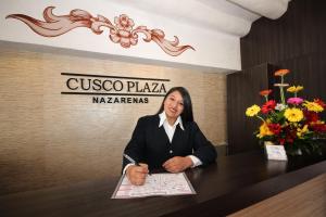una donna seduta a un tavolo con un giornale di Cusco Plaza Nazarenas a Cuzco