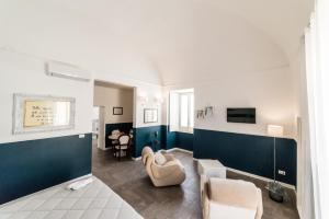 uma sala de estar com paredes azuis e brancas em Novecento Dimore di Poesia em Trani
