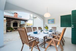 a dining room with a table and chairs and a fireplace at Villa Lapis Vis in Rukavac