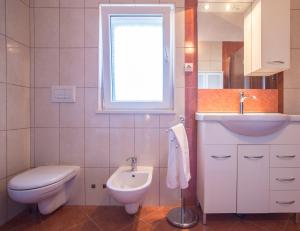 a white bathroom with a sink and a toilet at Villa Lapis Vis in Rukavac +21 photos