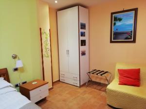 - une chambre avec un lit, une armoire et une chaise dans l'établissement b&b Sorrento Garden, à Sorrente