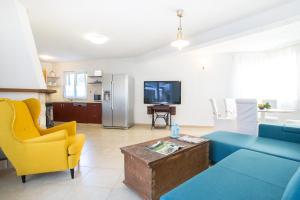 a living room with a blue couch and yellow chairs at Villa Lapis Vis in Rukavac