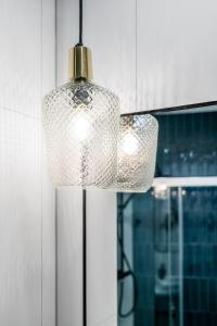 een glazen lamp die aan een keukenkastje hangt bij Ideal Apartments Green & Blue in Gdańsk