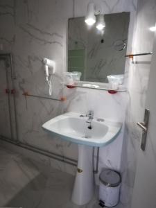 La salle de bains est pourvue d'un lavabo et d'un miroir. dans l'établissement Hotel Cristo Rei, à Porto