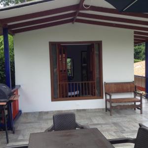 a patio with a table and a chair and a mirror at Finca El Sueño De Mi Abuelo in Pereira