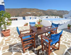 a wooden table and chairs on the roof of a house at Pension Christina in Aegiali