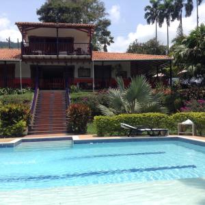a house with a swimming pool in front of a house at Finca El Sueño De Mi Abuelo in Pereira