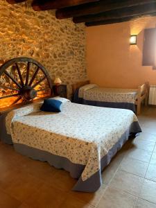 1 dormitorio con 2 camas y una rueda arbolada en Masia de la Serra de la Cogulla, en Peñarroya de Tastavins