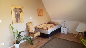 a small bedroom with a bed and a chair at Zimmervermietung Seefeld in Lingen