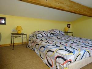 Un dormitorio con una cama con un edredón colorido. en Mas de l'AGUARELLA, en Saint-Rémy-de-Provence