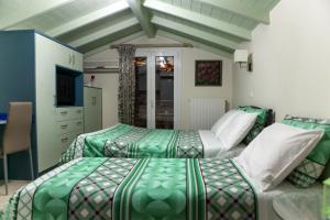 1 dormitorio con 2 camas y TV. en Blue Sky, en Nauplia