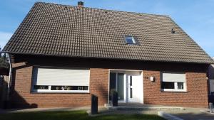 a brick house with a window and a roof at Zimmervermietung Seefeld in Lingen